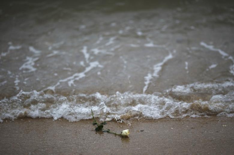 A rose is seen on the beach after being released by Thai children near a wave-shaped tsunami monument for victims of the 2004 tsunami in Ban Nam Khem, a southern fishing village destroyed by the wave December 26, 2014. REUTERS/Athit Perawongmetha