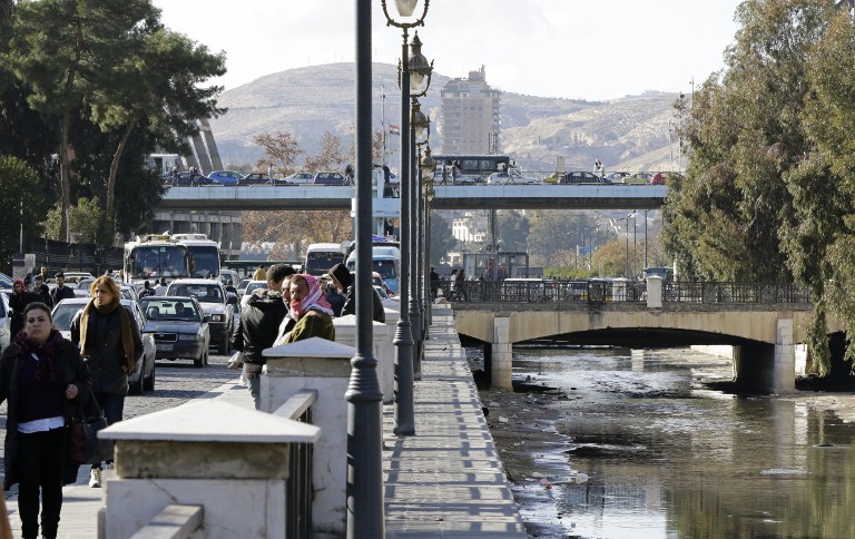 A general view shows people walking near the Barada river in the Syrian capital Damascus on January 3, 2017. The regime of President Bashar al-Assad is trying to seize control of the region which supplies the main drinking water for four million inhabitants of the capital and surrounding areas. / AFP PHOTO / LOUAI BESHARA