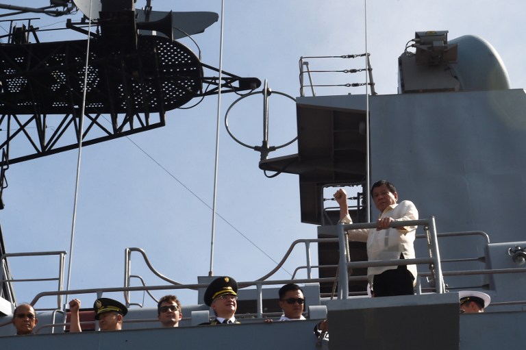 Philippines' President Rodrigo Duterte raises a clinched fist as he visits the Russian anti-submarine navy ship Admiral Tributs in Manila on January 6, 2017. The Russian Navy said January 3 it was planning to hold war games with the Philippines, as two of its ships made a rare stop in Manila following Filipino President Rodrigo Duterte's pivot from the United States. / AFP PHOTO / Ted ALJIBE