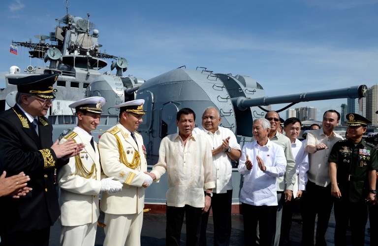 Philippines' President Rodrigo Duterte (4th L) shake hands with Russia's Rear Admiral Eduard Mikhailov (3rd L) onboard the Russian anti-submarine navy ship Admiral Tributs in Manila on January 6, 2017. The Russian Navy said on January 3 it was planning to hold war games with the Philippines, as two of its ships made a rare stop in Manila following Filipino President Rodrigo Duterte's pivot from the United States. / AFP PHOTO / POOL / Noel CELIS