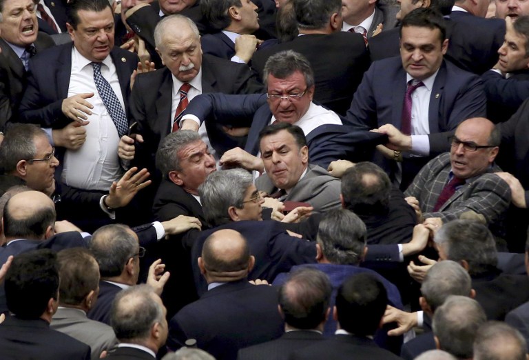 Ruling Justice and Development Party and main opposition Republican People's Party lawmakers scuffle at the parliament in Ankara during deliberations over a controversial 18-article bill to change the constitution to create an executive presidency January 11, 2017. Turkish lawmakers on Thursday approved three more articles in a hugely controversial bill bolstering the powers of President Recep Tayyip Erdogan, as lawmakers brawled and threw objects in a session of high tension. A brawl erupted in the chamber as the voting took place in an overnight session, with lawmakers punching each another and chairs being thrown, television pictures showed.  / AFP PHOTO / Adem ALTAN