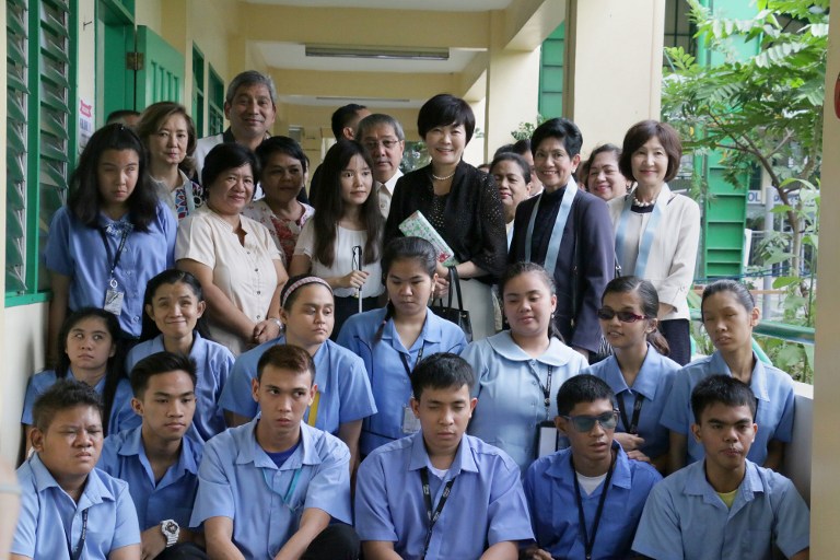 Akie Abe (top C), wife of visiting Japanese Prime Minister Shinzo Abe, poses with students during a visit to the Philippine National School for the Blind (PNSB) in Manila on January 12, 2017. Japanese Prime Minister Shinzo Abe arrived in the Philippines earlier on January 12, becoming the first foreign leader to visit since President Rodrigo Duterte took office last year and launched his deadly war on crime. / AFP PHOTO / Joseph Agcaoili