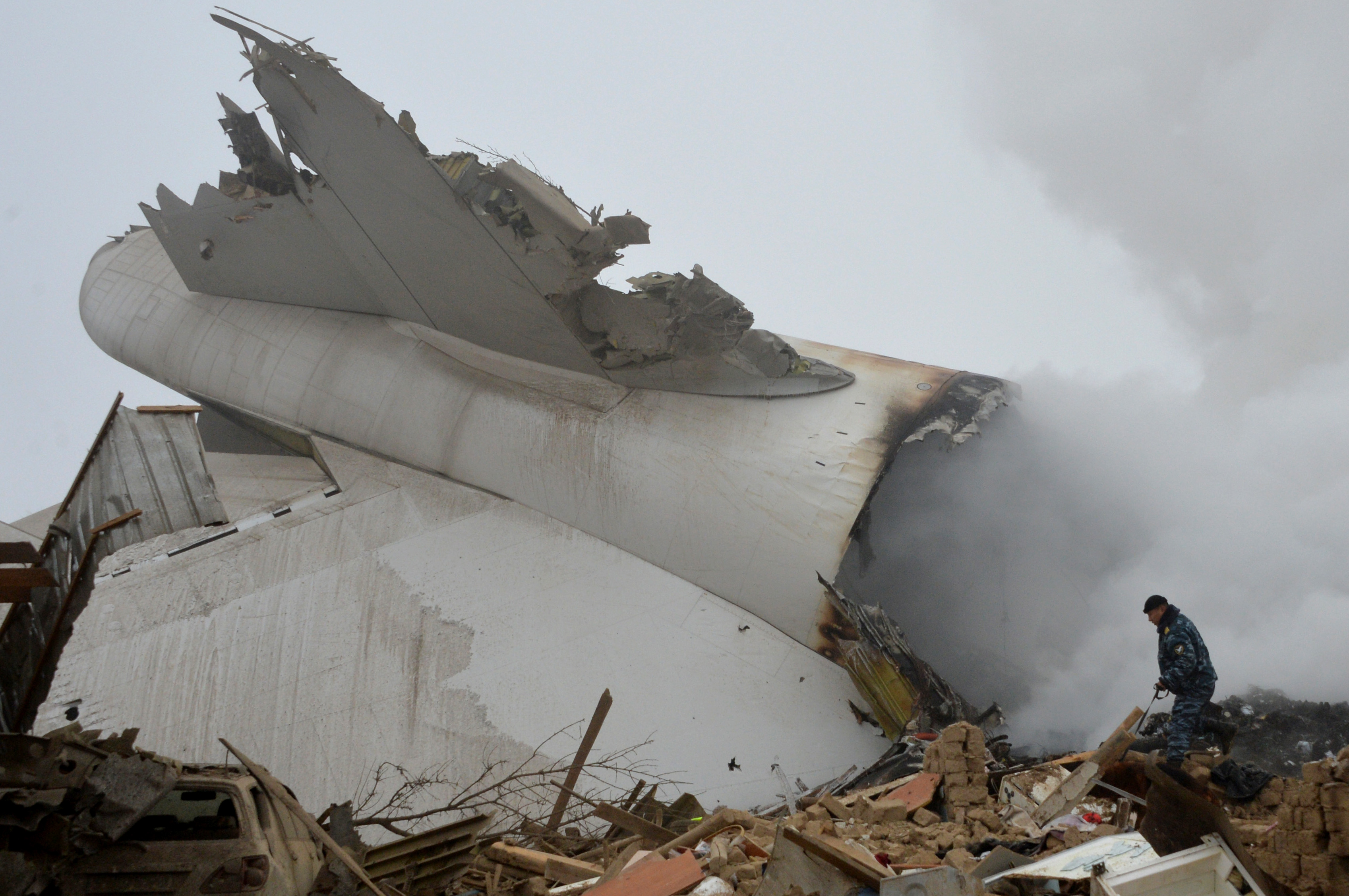 A police officer works at the crash site of a Turkish cargo plane in the village of Dacha-Suu outside Bishkek on January 16, 2017. A Turkish cargo plane crashed into a village near Kyrgyzstan's main airport Monday, killing 32 people and destroying homes after attempting to land in thick fog, authorities said. / AFP PHOTO / Vyacheslav OSELEDKO