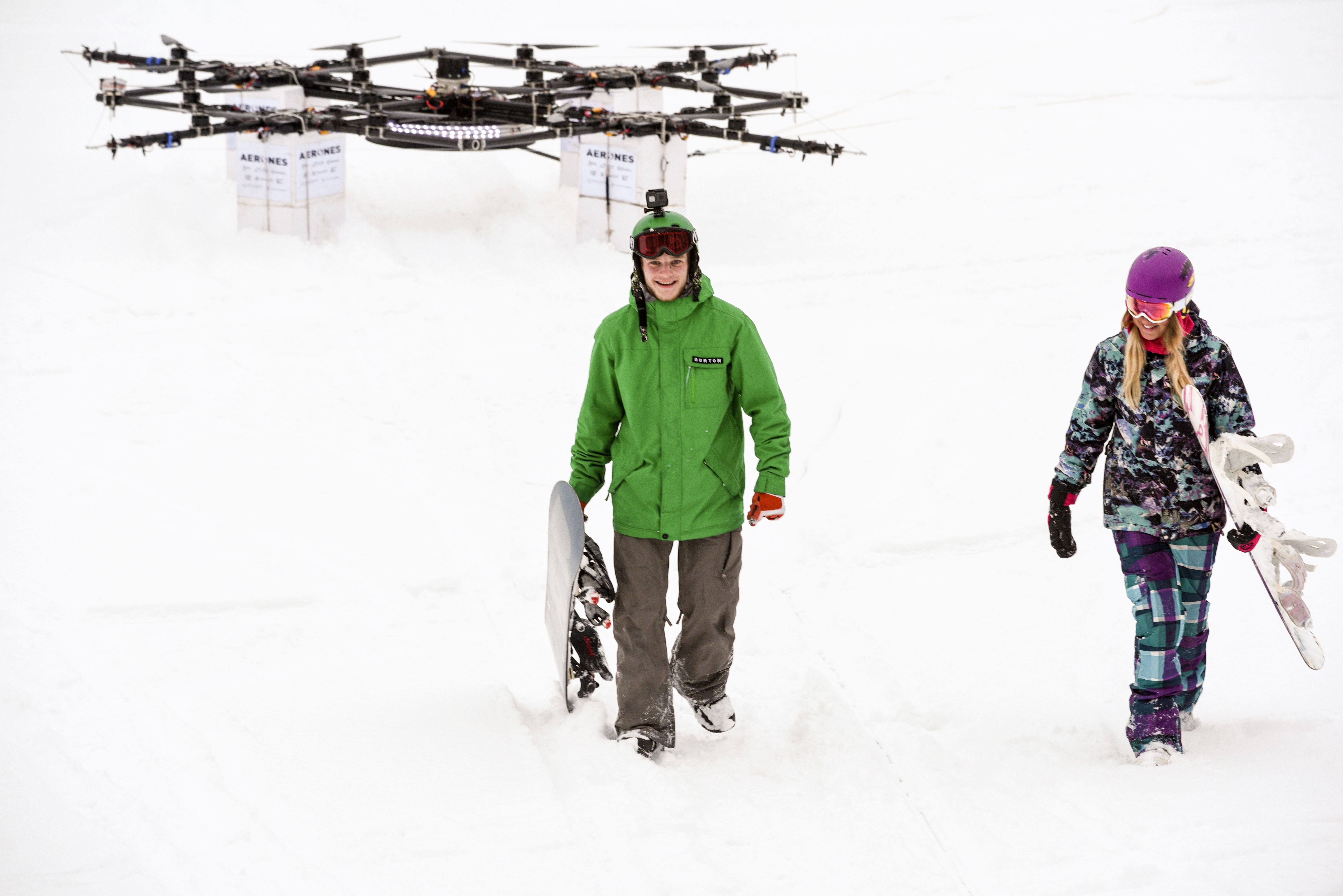 Davis Ceize (L) and Anita Leina (R) walk after droneboarding on Niniera lake surface near Cesis, Latvia, on January 14, 2017. / AFP PHOTO / Ilmars ZNOTINS