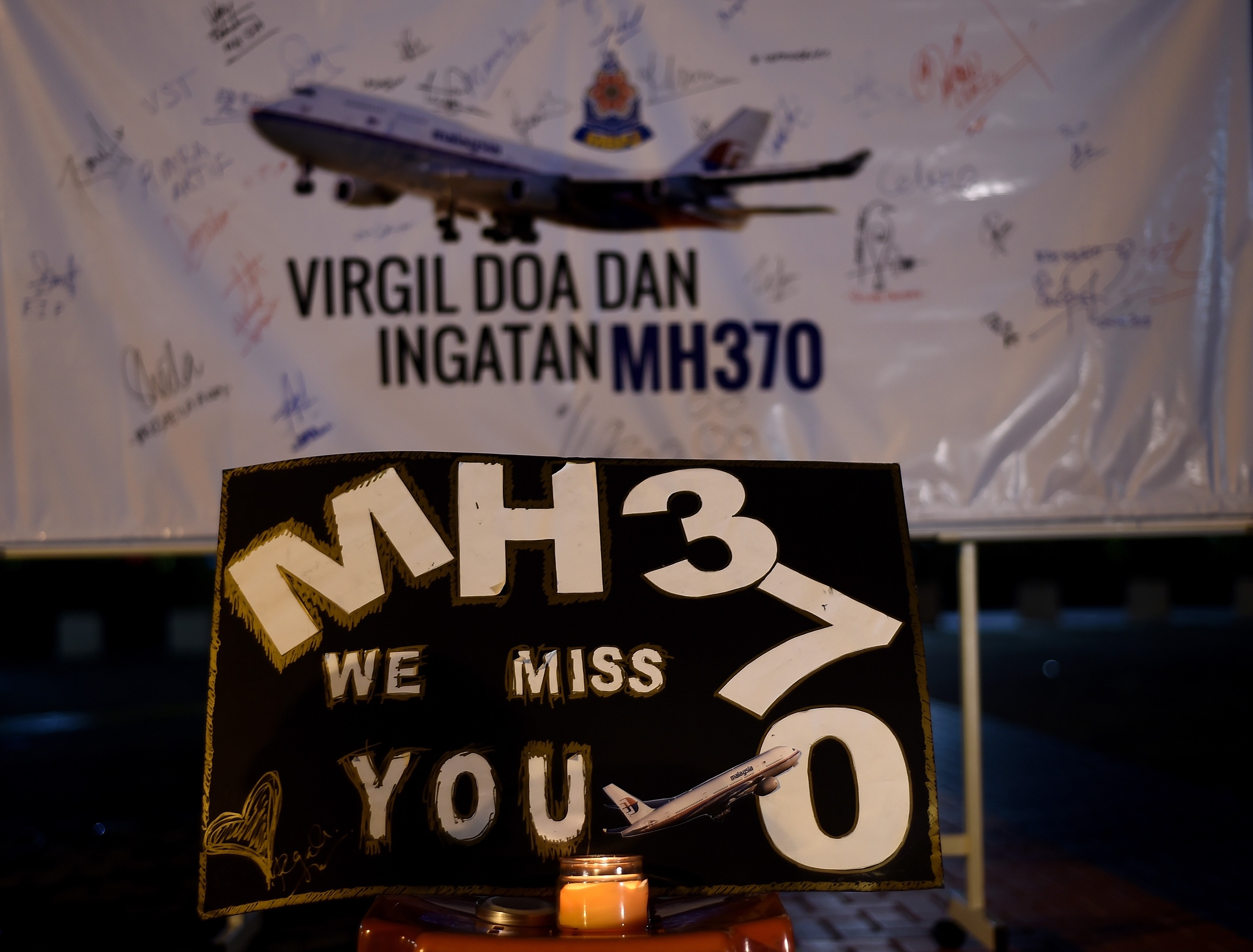 (FILES) This file picture taken on March 6, 2015 shows a board bearing solidarity messages during a gathering to mark the one-year anniversary of the disappearance of Malaysia Airlines flight MH370 in Kuala Lumpur.  The deep ocean hunt for missing passenger jet MH370 has been suspended after nearly three years without result, the Australian, Malaysian and Chinese governments said on January 17, 2017. / AFP PHOTO / MANAN VATSYAYANA