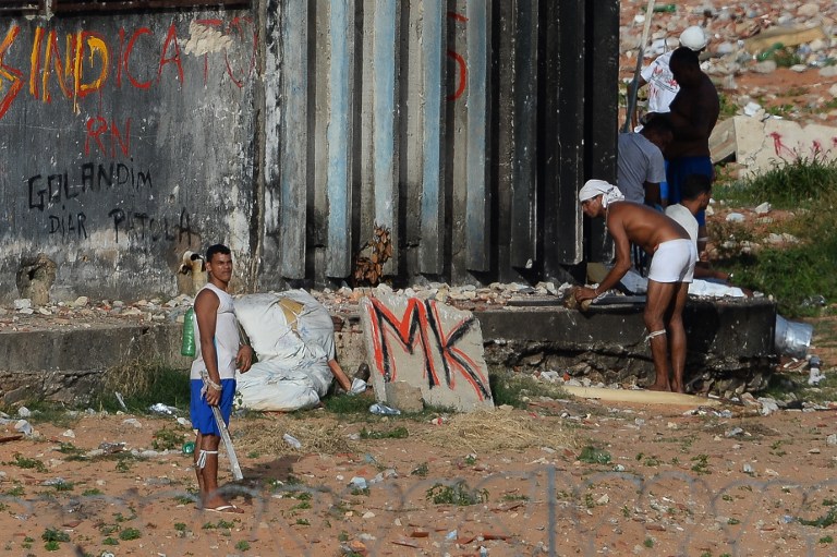 Prisoners during a riot at the Alcacuz Penitentiary Center near Natal in Rio Grande do Norte, Brazil on January 17, 2017.  Brazilian police fired rubber bullets Tuesday at inmates who have taken over a jail where dozens were massacred over the weekend in the latest in a string of prison riots. Police positioned on top of the outer walls of the Alcacuz jail near the northeastern city of Natal fired at a crowd of inmates who had taken control of part of the complex. A total of 26 prisoners were killed in Alcacuz -- many of them beheaded -- during a violent riot that broke out late Saturday, according to officials.  / AFP PHOTO / ANDRESSA ANHOLETE
