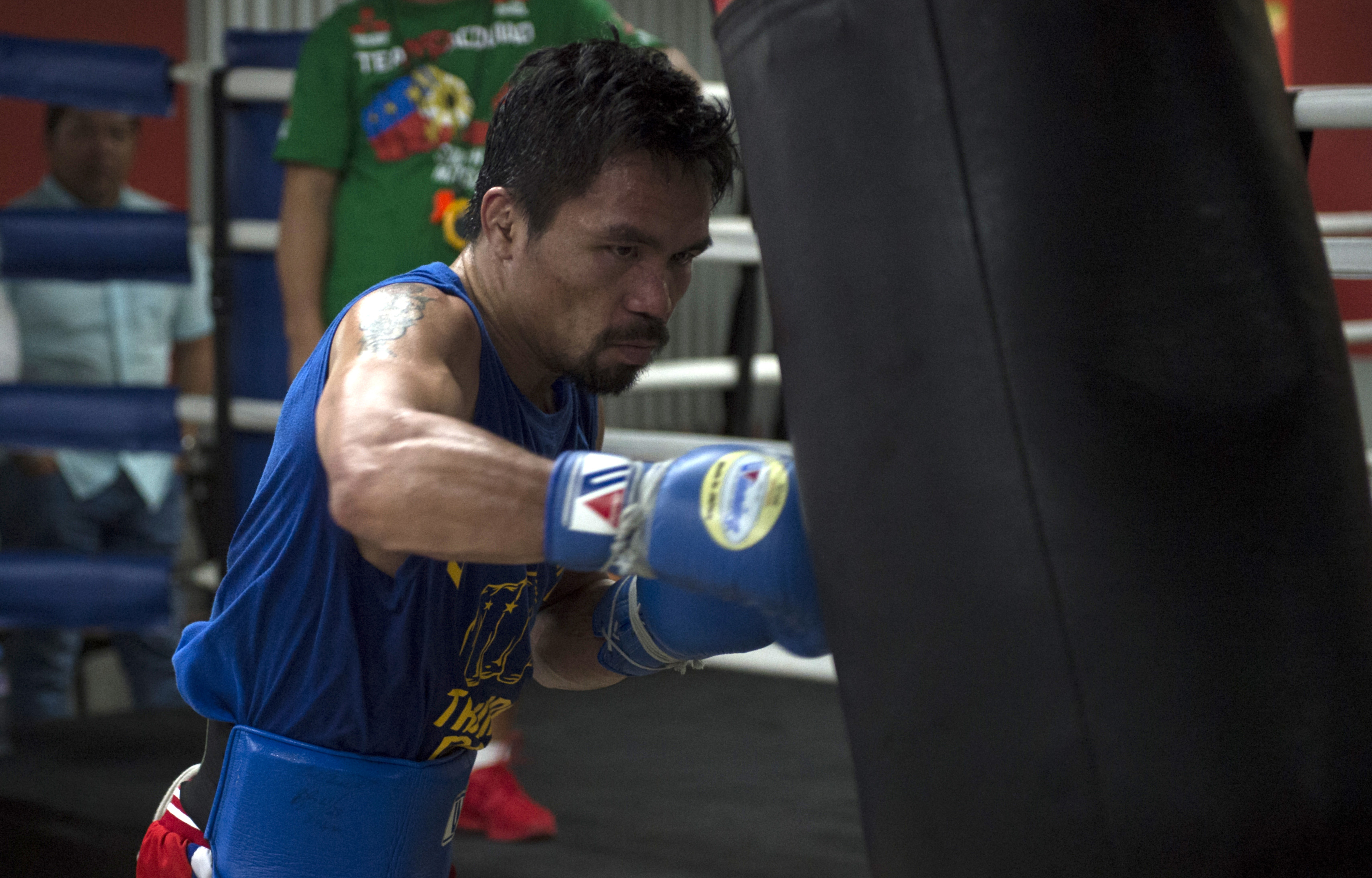 (FILES) This file photo taken on September 29, 2016 shows Philippine boxer Manny Pacquiao training at a gym in Manila. WBO welterweight world champion Manny Pacquiao is willing to square up with mixed martial arts star Conor McGregor if his potential superfight with Floyd Mayweather fails to materialise, a spokesman said on January 22, 2017.  / AFP PHOTO / TED ALJIBE