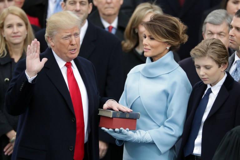 WASHINGTON, DC - JANUARY 20: (L-R) U.S. President Donald Trump takes the oath of office as his wife Melania Trump holds the bible and his son Barron Trump looks on, on the West Front of the U.S. Capitol on January 20, 2017 in Washington, DC. In today's inauguration ceremony Donald J. Trump becomes the 45th president of the United States.   Chip Somodevilla/Getty Images/AFP