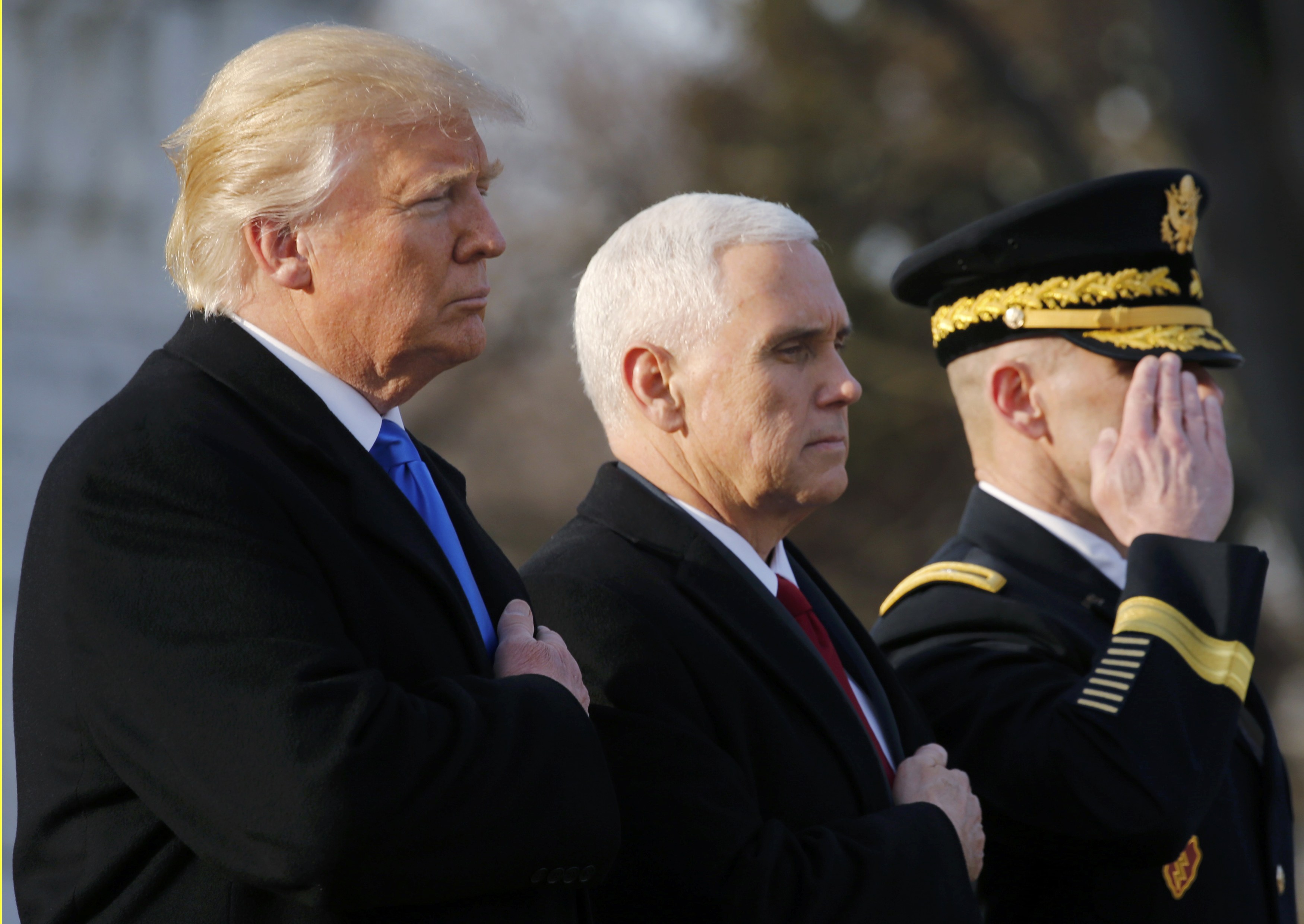 U.S. President-elect Donald Trump (L) and Vice President-elect Mike Pence (C) participate in a wreath laying ceremony at Arlington National Cemetery outside Washington, U.S., January 19, 2017, one day before Trump's inauguration as the nation's 45th president. REUTERS/Jonathan Ernst