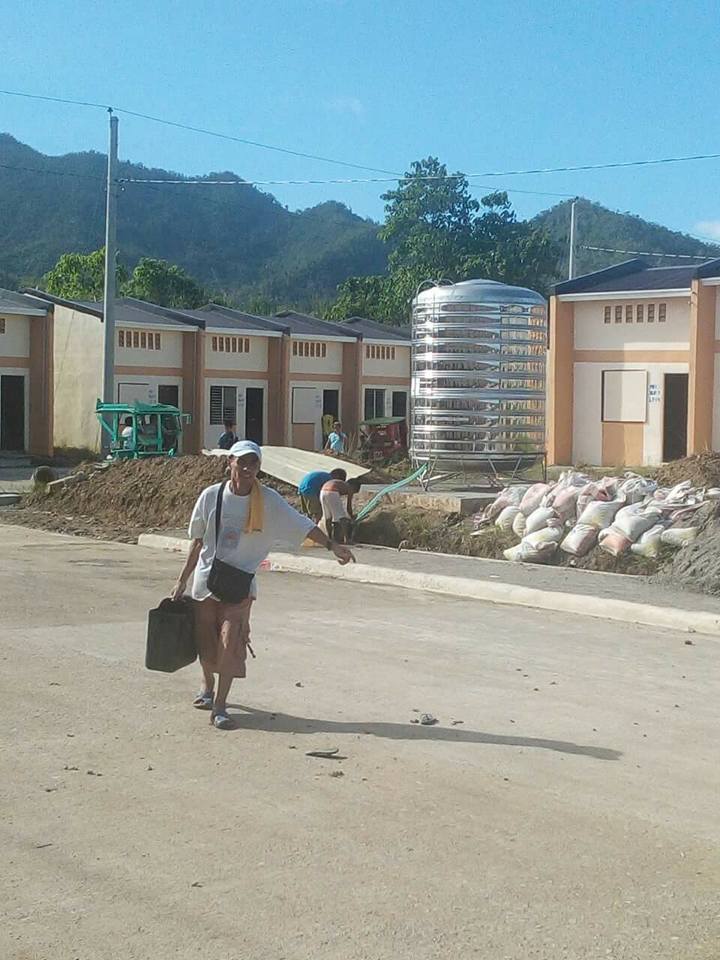 A man carrying a gallon of potable water from the Installed tanks in the relocation site for the typhoon yolanda victims. Photo is courtesy of the Office of the Presidential Assistant for the Visayas.