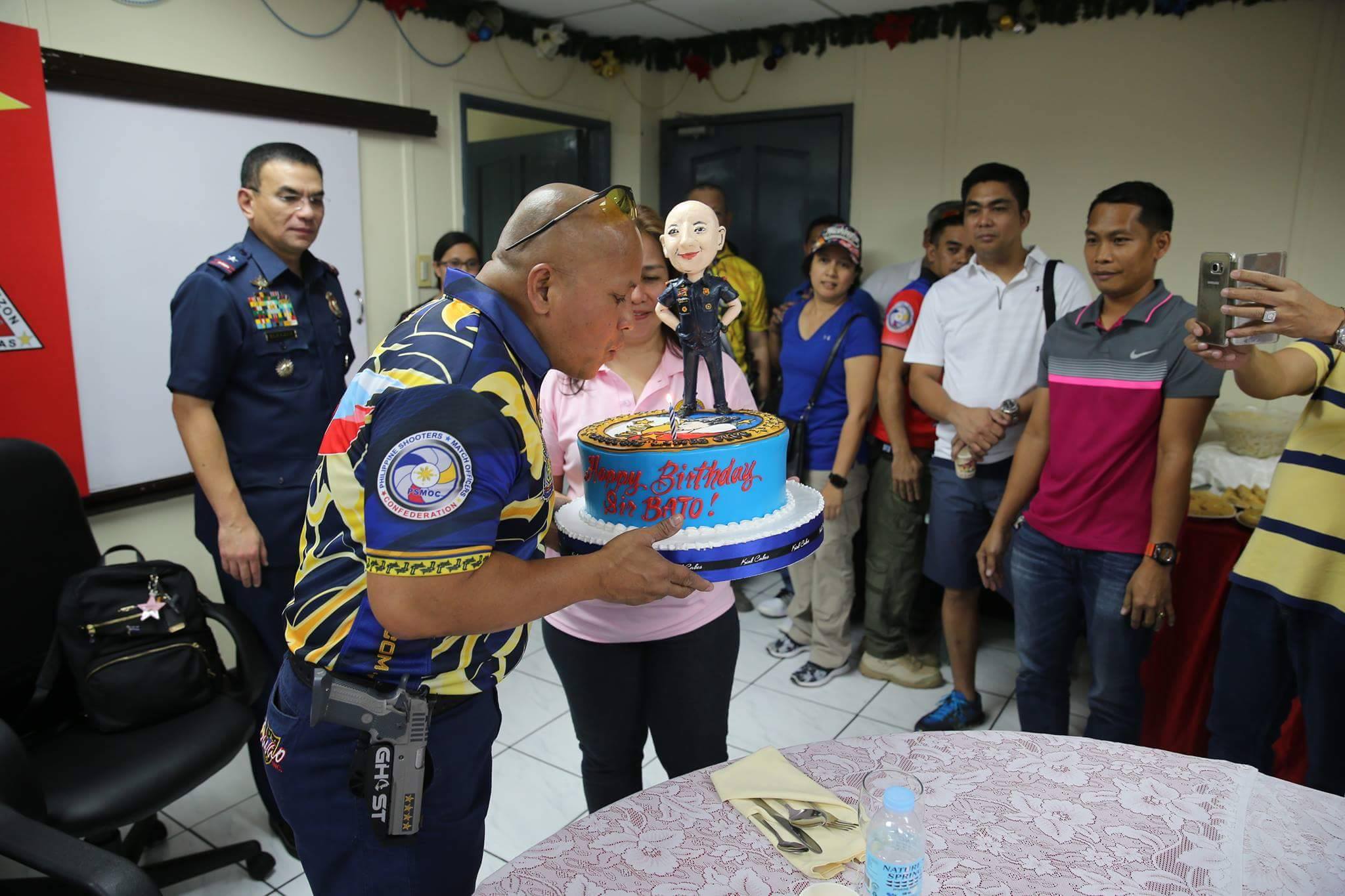 Philippine National Police chief Director General Ronald "Bato" Dela Rosa blows a  candle on a birthday cake given to him by fellow police officers.  (Photo courtesy PNP-PIO)