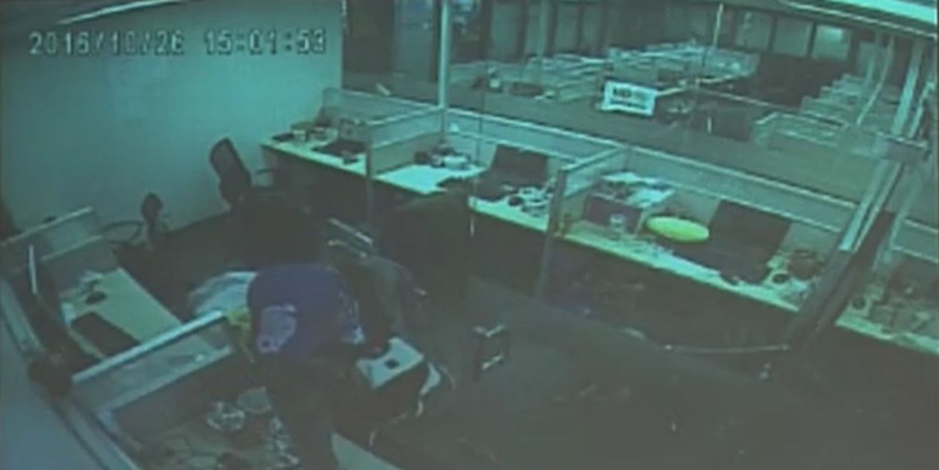The cop in civilian clothes allegedly "planting" drugs inside office drawers. (Photo grabbed from CCTV footage shown by Senator Panfilo Lacson during a Senate inquiry into the alleged "tokhang for ransom" activities of rogue cops on Thursday, January 26, 2016.