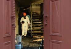 A police investigator secures evidences in a house damaged by a fire in Vorra, near Nuremberg, southern Germany, on December 12, 2014. During the night, fire brigades extinguished fires at three buildings under renovation that were aimed for use as refugee accomodations. Police investigate the cases in suspicion of arson attacks.    AFP PHOTO / CHRISTOF STACHE / AFP PHOTO / CHRISTOF STACHE