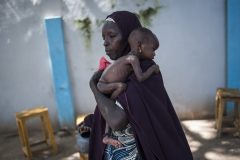 This photo taken on September 15, 2016 shows a mother holding her young malnourished baby at a public health facility in the Dalaram district of Maiduguri, northeast Nigeria.  Aid agencies have long warned about the risk of food shortages in northeast Nigeria because of the conflict, which has killed at least 20,000 since 2009 and left more than 2.6 million homeless. In July, the United Nations said nearly 250,000 children under five could suffer from severe acute malnutrition this year in Borno state alone and one in five -- some 50,000 -- could die.  / AFP PHOTO / STEFAN HEUNIS