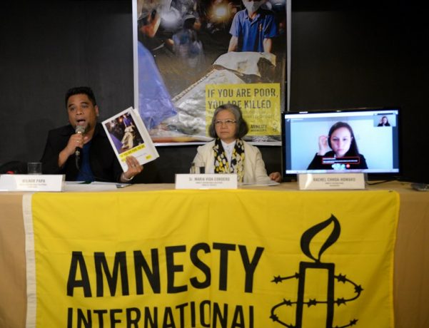 Wilnor Papa, from Amnesty International Philippines, shows a copy of their report during a press conference in Manila on February 1, 2017. Philippine police may have committed crimes against humanity by killing thousands of alleged drug offenders or paying others to murder as part of President Rodrigo Duterte's drug war, Amnesty International said February 1. TED ALJIBE / AFP