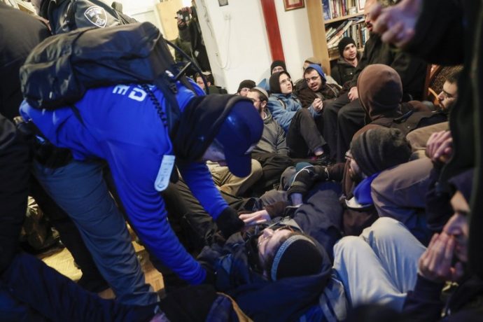 Jewish settlers lie on the floor as Israeli security forces evict hardline residents from the wildcat Amona outpost, northeast of Ramallah, on February 1, 2017, in line with a High Court ruling that determined the homes were built on private Palestinian land. Israeli police began evicting dozens of hardline Jewish settlers from a wildcat outpost, just hours after unveiling plans for 3,000 new homes in other West Bank settlements.