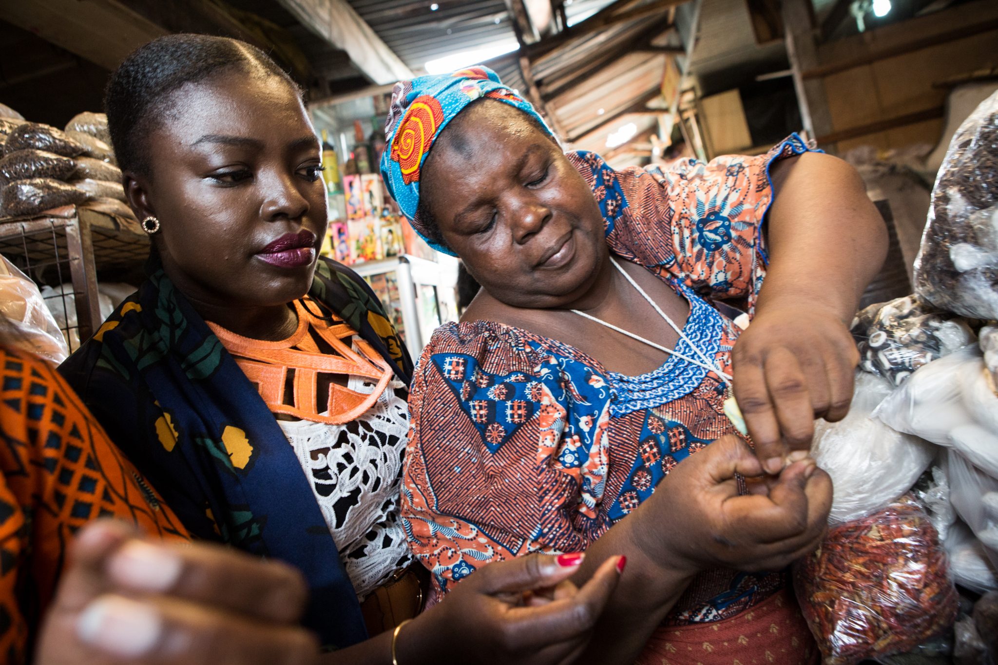 Essie Bartels buys spices from her seller Aisha Ibrahim at the Makola market in Accra, on January 25, 2017. It took a move to the United States from Ghana to convince food entrepreneur Essie Bartels that the world deserved to know more about west African cuisine. Bartels saw a gap in the market and dedicated herself to creating sauces and spice blends inspired by her childhood in Ghana's capital, Accra, through her company Essie Spice. / AFP PHOTO / Ruth McDowall