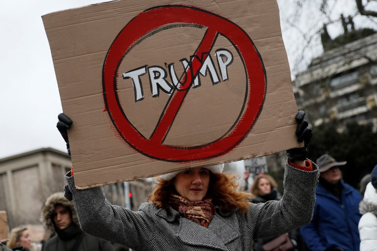 An anti-Trump protester holds a sign during a demonstration in Paris, on February 4, 2017. US President Donald Trump lashed out on February 4, 2017 at a court ruling suspending his controversial ban on travelers from seven Muslim countries, dismissing it as "ridiculous" and vowing to get it overturned. The order blocking the ban, issued late on February 3, 2017 by Seattle US District Judge James Robart, is valid across the United States, pending a full review of a complaint filed by Washington state's attorney general. / AFP PHOTO / THOMAS SAMSON