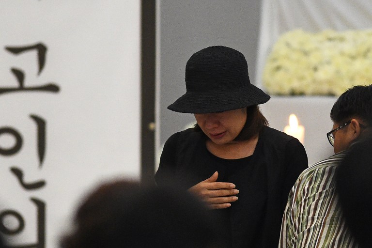 Choi Kyung-Jin (C), widow of late South Korean businessman Jee Ick-Joo who was allegedly killed by suspected policemen, walks towards her seat after offering prayers during a memorial service for her late husband at the police national headquarters in Manila on February 6, 2017. The South Korean businessman was allegedly kidnapped by Philippine policemen under the guise of a raid on illegal drugs and murdered at the national police headquarters in Manila, authorities said on January 18. / AFP PHOTO / TED ALJIBE