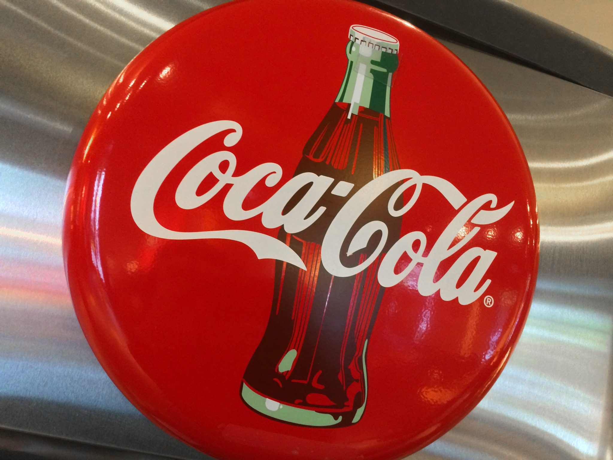 (FILES) This file photo taken on May 1, 2016 shows a Coca-Cola logo in a restaurant in Washington, DC. Coca-Cola said February 9, 2017 the strong US dollar again hit results in some overseas markets, leading to lower fourth-quarter earnings, although it scored higher revenues in North America.The soft drink giant said net income for the quarter ending December 31 fell to $550 million, down 55.5 percent from the final quarter of 2015, due in part to costs associated with the sale of the company's North American bottling operations to franchisers. / AFP PHOTO / Karen BLEIER