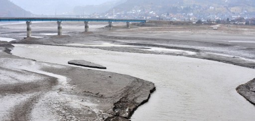 (FILES) This file photo taken on February 7, 2017 the Neretva's River running through the banks of the artificial lake Jablanicko near the Bosnian town of Konjic. Bosnia's fisheries watchdog gazes over an expanse of sand and mud, a space once occupied by a large thriving lake but recently emptied in the race for electricity production. The water level should soon begin to rise again, with snow on the surrounding mountains melting and rains starting to fall after a prolonged period of drought. But fishermen and environmental groups say the damage has been done, with stocks of "more than two million" fish, such as perch and trout, "devastated" by the sudden drop in water about 40 days ago. / AFP PHOTO / ELVIS BARUKCIC