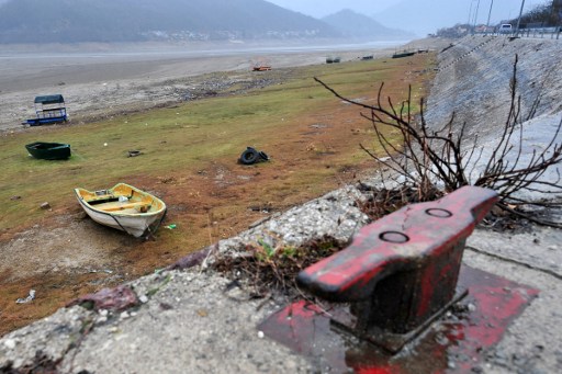 (FILES) This file photo taken on February 07, 2017 shows stranded rafts and pontoons near the shores of the Jablanicko artificial lake near the Bosnian town of Konjic. Bosnia's fisheries watchdog gazes over an expanse of sand and mud, a space once occupied by a large thriving lake but recently emptied in the race for electricity production. The water level should soon begin to rise again, with snow on the surrounding mountains melting and rains starting to fall after a prolonged period of drought. But fishermen and environmental groups say the damage has been done, with stocks of "more than two million" fish, such as perch and trout, "devastated" by the sudden drop in water about 40 days ago. / AFP PHOTO / ELVIS BARUKCIC