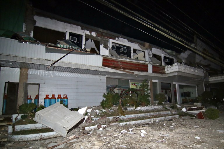 Debris litter next to a destroyed hotel after a 6.5-magnitude earthquake struck overnight in Surigao City, in southern island of Mindanao, early February 11, 2017.  A strong quake shook the southern Philippines on February 10, killing at least three people, toppling buildings and sending panicked residents fleeing their homes, media reports and authorities said. / AFP PHOTO / ERWIN MASCARINAS