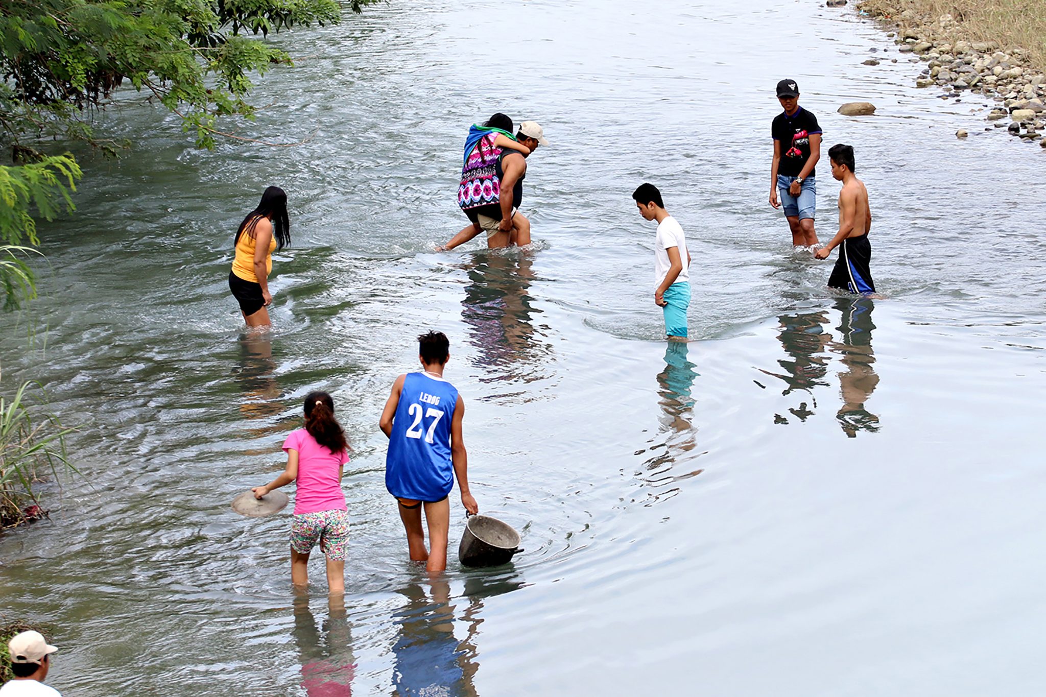 Residents cross a river after a bridge linking the city to nearby towns was destroyed, after a 6.5-magnitude earthquake struck overnight, in Surigao City in the southern island of Mindanao on February 11, 2017. Rescuers dug through rubble on February 11 to find survivors after a powerful earthquake struck the southern Philippines, killing at least four people and sending thousands fleeing for safety. / AFP PHOTO / ERWIN MASCARINAS