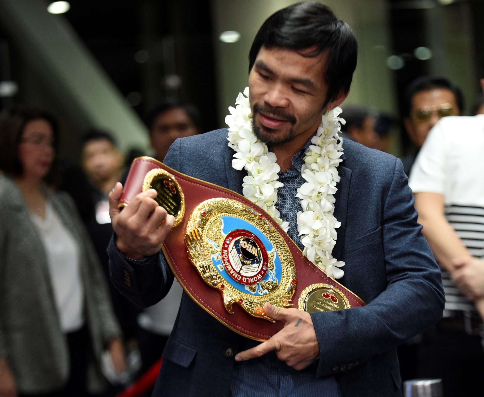 (FILES) This file photo taken on November 8, 2016 shows Philippine boxing icon Manny Pacquiao holding up his welterweight title upon his arrival at the airport in Manila. Manny Pacquiao on February 13, 2017 asked his legions of Twitter followers to choose his opponent after announcing his next world title defence will be in the United Arab Emirates. / AFP PHOTO / Ted ALJIBE