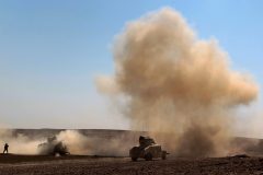 Smoke billows in the background as Iraqi forces, supported by the Hashed al-Shaabi (Popular Mobilisation) paramilitaries, advance near the village of Husseinyah, south of Mosul on February 20, 2017, during the offensive to retake the western side of Mosul. / AFP PHOTO / AHMAD AL-RUBAYE