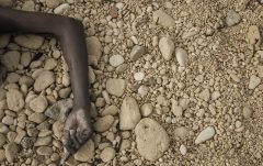EDITORS NOTE: Graphic content / A handout picture released on February 21, 2017 by the Al-Zawiyah Branch of the Libyan Red Crescent shows the arm of a dead migrant on the beach as Libyan Red Crescent volunteers recover the bodies of 74 migrants that washed ashore on February 20 near Zawiyah on Libyas northern coast.  The International Organization for Migration (IOM) said the boat was reported to have foundered leaving as many as 100 people dead. The agency said that if confirmed, the deaths would bring the total number of migrants killed trying to cross the Mediterranean so far this year to more than 365.  / AFP PHOTO / Al-Zawiyah Branch - Libyan Red Crescent / Amin ELAMR / RESTRICTED TO EDITORIAL USE - MANDATORY CREDIT "AFP PHOTO / AL-ZAWIYAH BRANCH - LIBYAN RED CRESCENT / AMIN ALAMR" - NO MARKETING - NO ADVERTISING CAMPAIGNS - DISTRIBUTED AS A SERVICE TO CLIENTS
