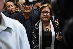 Philippine Senator Leila De Lima (centre R), a top critic of President Rodrigo Duterte, is escorted by security personnel as she walks to a press conference in the senate in Manila on February 23, 2017, as she awaits the warrant of arrest to be served. An arrest warrant was issued February 23, for the highest-profile opponent of Philippine President Rodrigo Duterte's brutal war on drugs, outraging her supporters who said the move was aimed at silencing her. Senator Leila de Lima, 57, a lawyer who has spent nearly a decade trying to link Duterte to death squads that have allegedly killed thousands of people, faces drug trafficking charges that could see her jailed for life. / AFP PHOTO / TED ALJIBE