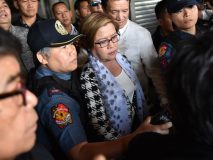 Philippine Senator Leila De Lima (C), a top critic of President Rodrigo Duterte, is escorted by police officers and her lawyer Alex Padilla (R, in white long sleeves) after her arrest at the Senate in Manila on February 24, 2017. / AFP PHOTO / TED ALJIBE