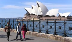 Tourist walk along the seafront near the Sydney Opera House on September 7, 2016 Australia's economy grew by 0.5 percent in the June quarter with an upswing in government spending offsetting a fall in net exports as the nation marked 25 years of unbroken economic expansion. / AFP PHOTO / WILLIAM WEST