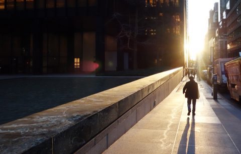 A man walks down a sidewalk on the east side of Manhattan as the sun rises January 19, 2017 in New York. / AFP PHOTO / Don EMMERT
