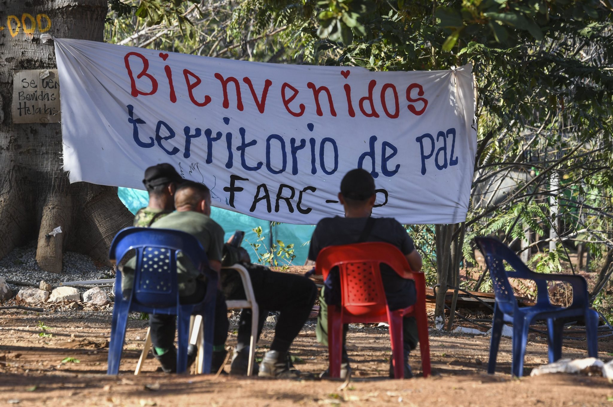 Members of the FARC leftist guerrilla rest at the entrance to the area where the rebels are gathering in the municipality of San Jose de Oriente, Cesar department, northern Colombia on February 28, 2017. The initial phase of the FARC disarmament process, which includes making an inventory of weapons and destroying unstable munitions, begins on March 1 according to the timetable agreed in the peace pact between the rebels and the government in November 2016.  / AFP PHOTO / Luis Acosta