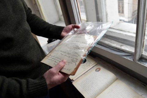 A picture taken on February 27, 2017 shows historian Mikhail Melnichenko, 33, displaying pages from a Soviet-era diary during an AFP interview in Moscow. An enthusiastic group of young Russian historians and volunteers publishes hundreds of never-before-seen Stalin-era diaries on a website called Prozhito, or Lived Through. The site was launched in 2015 and can be searched using the day, author or a keyword. It already includes more than 600 never-published journals. / AFP PHOTO / Natalia KOLESNIKOVA / TO GO WITH AFP STORY BY Anna MALPAS