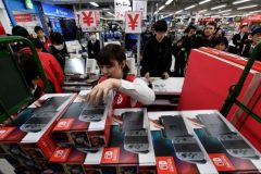 A shop clerk picks a package of a Nintendo Switch game console at cashier of a shop in Tokyo on March 3, 2017. Nintendo's new game console, Switch is put on the Japanese market from March 3, 2017. / AFP PHOTO / TOSHIFUMI KITAMURA