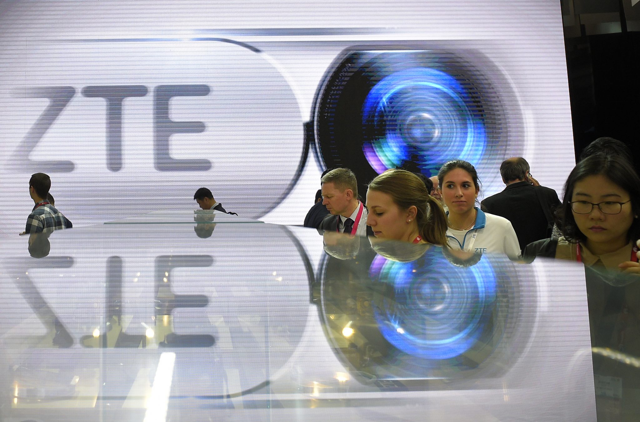 (FILES) This file photo taken on February 23, 2016 shows visitors testing smart phones at the ZTE's stand during the Mobile World Congress in Barcelona. The US government has slapped $1.2 billion in fines on Chinese telecom giant ZTE for violations of US export controls for selling goods to Iran and North Korea, officials announced on March 7, 2017. It is the largest criminal penalty in US history in an export control case, government officials said. The company will pay $892 million, while another $300 million in penalties are suspended for seven years. ZTE also agreed to plead guilty to three charges, including obstructing justice for hiding information from government investigators, the officials said. The agreement is subject to court approval.  / AFP PHOTO / LLUIS GENE