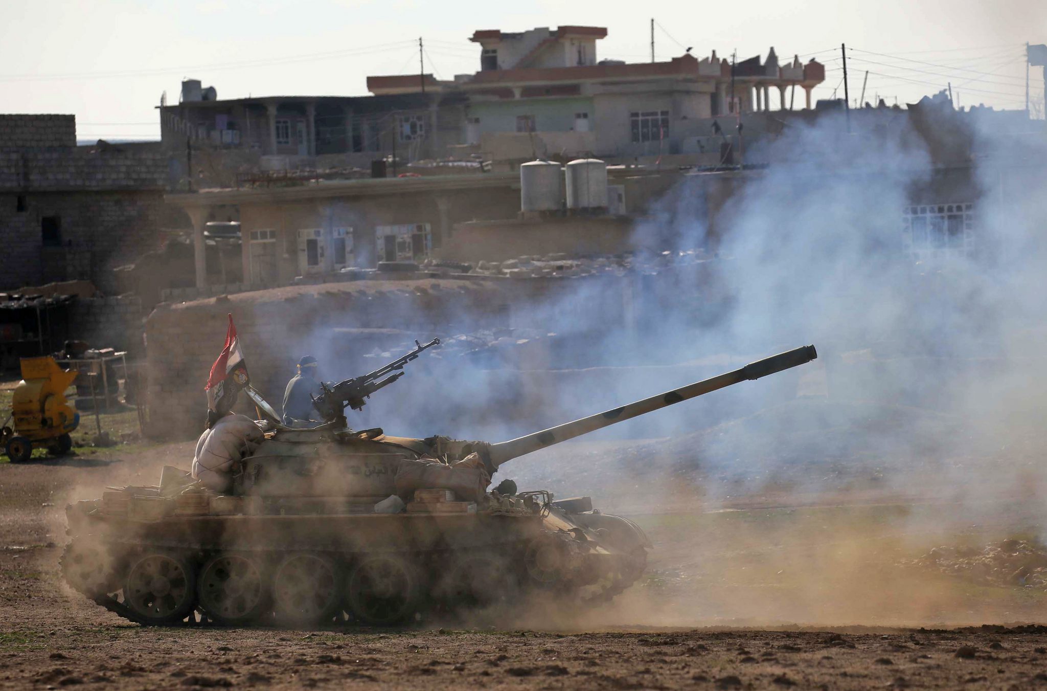 Iraqi government forces supported by fighters from the Abbas Brigade, which fight under the umbrella of the Shiite popular mobilisation units, advance in village of Badush some 15 kilometres northwest of Mosul during the ongoing battle to retake the city's west from Islamic State (IS) group jihadists on March 7, 2017. / AFP PHOTO / Mohammed SAWAF