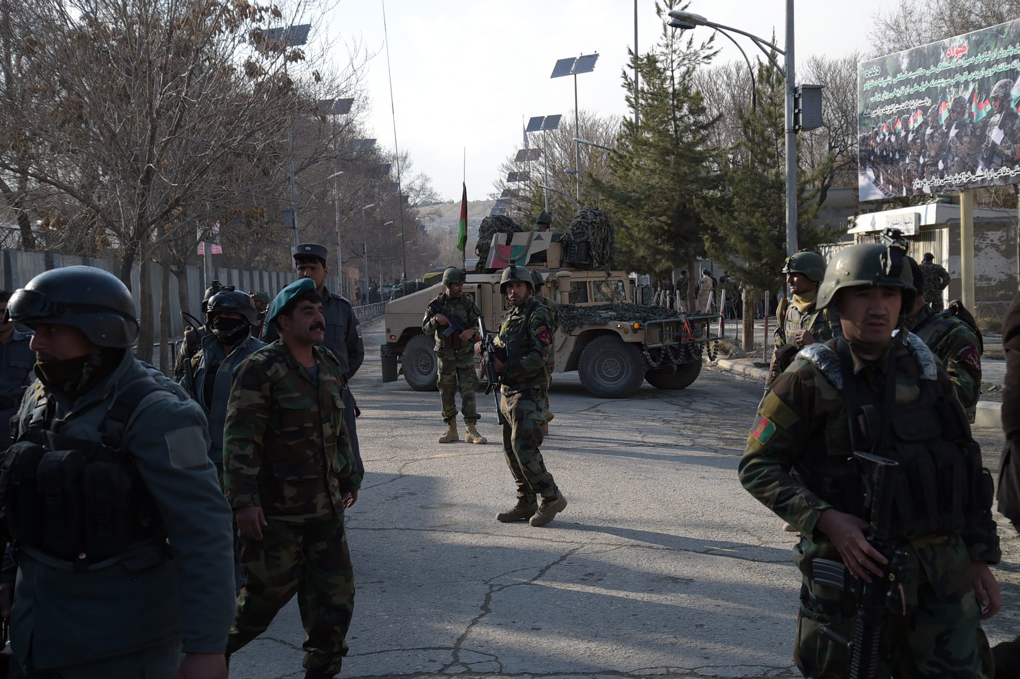 Afghan security personnel stand guard in front of the main gate of a military hospital in Kabul on March 8, 2017, after a deadly six-hour attack claimed by the Islamic State group. More than 30 people were killed and around 50 wounded in an insurgent attack on Afghanistan's largest military hospital in Kabul on March 8, the defence ministry said.  / AFP PHOTO / SHAH MARAI