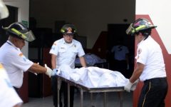 Handout picture released by Guatemalan Volunteer Firefighters showing three firefighters carrying the corpse of one of the the 20 victims of a fire at children's shelter Virgen de la Asuncion facility, in San Jose Pinula, about 10 kilometres east of Guatemala City, on March 8, 2017. At least 20 teenage girls died in a fire at a children's shelter in Guatemala, a spokesman for the local fire service said. It was not immediately known how many of the bodies were those of children. The center, supervised by state social welfare authorities, hosts minors who are victims of family mistreatment. The facility has been the target of multiple complaints alleging abuse, and several children have run away. / AFP PHOTO / Guatemalan Volunteer Firefighters / HO / RESTRICTED TO EDITORIAL USE - MANDATORY CREDIT "AFP PHOTO /Guatemalan Volunteer Firefighters /HO " - NO MARKETING - NO ADVERTISING CAMPAIGNS - DISTRIBUTED AS A SERVICE TO CLIENTS