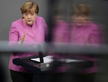 German Chancellor Angela Merkel is reflected in a glass surface during her speech at a session of the German lower house of parliament Bundestag in Berlin on March 9, 2017.  Chancellor Angela Merkel said that Germany must not allow Turkey to "grow more distant", despite a bitter row in which President Recep Tayyip Erdogan has likened her government to the Nazis. / AFP PHOTO / Tobias SCHWARZ
