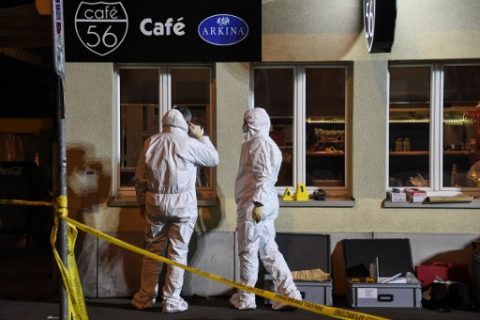 Police collect evidence at the site of a shooting on early March 10, 2017 in the city of Basel, north-west Switzerland. Two men shot dead two people and seriously injured a third at a cafe in Basel, north-west Switzerland, police said as they hunt for the suspects.   / AFP PHOTO / Sebastien Bozon