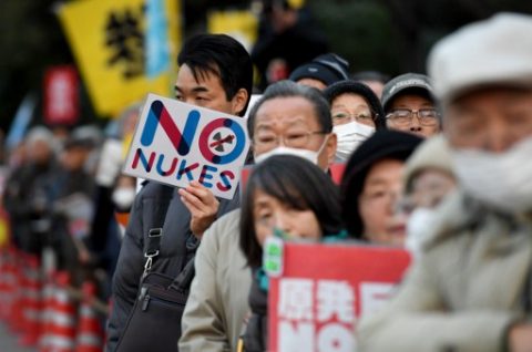 Holding banners, protesters join a demonstration in front of the parliament building in Tokyo on March 11, 2017, the sixth anniversary day of the a deadly earthquake, tsunami and nuclear disaster.  Several hundred demonstrators gathered near prime minister's official residence and in front of parliament to denounce government policy to restart nuclear reactors around the country. / AFP PHOTO / TOSHIFUMI KITAMURA