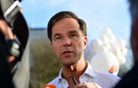 Dutch Prime Minister and leader of the People's Party for Freedom and Democracy (Volkspartij voor Vrijheid en Democratie - VVD) Mark Rutte answers journalists on his way to cheer marathon runners while campaigning for re-election, in The Hague, on March 12, 2017.  The Dutch parliamentary elections are set to take place on March 15, 2017 / AFP PHOTO / EMMANUEL DUNAND