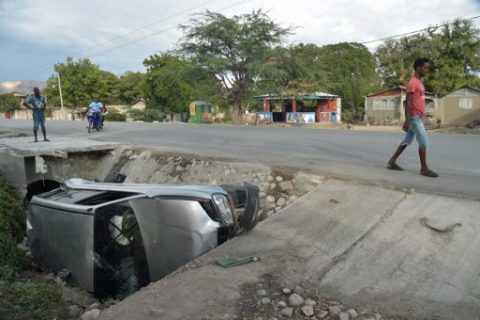 A car damaged by a bus lies on the side of a road on March 12, 2017 in Gonaives, 150 km (90 miles) northwest of the capital Port-au-Prince. A bus speeding away from a hit-and-run accident plowed into dozens of street musicians in northern Haiti, killing 34 people, officials said.  / AFP PHOTO / HECTOR RETAMAL