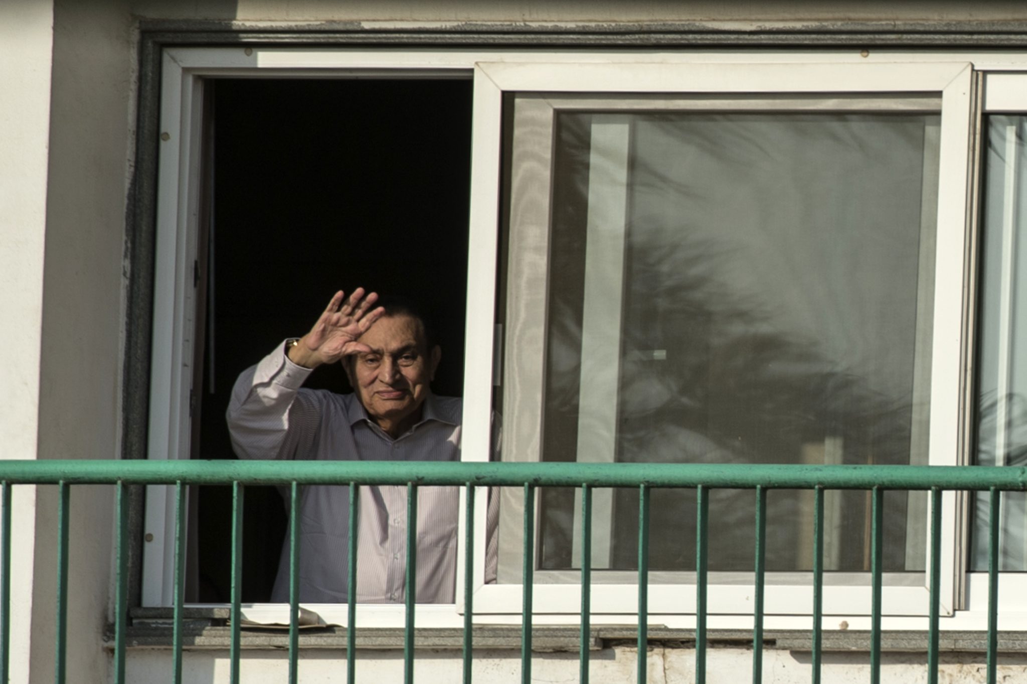 (FILES) This file photo taken on October 6, 2016 shows Egypt's former president Hosni Mubarak waving to people from his room at the Maadi military hospital in Cairo, as his supporters gather to celebrate the 43rd anniversary of October War victory. An Egyptian prosecutor allowed on March 13, 2017 for Mubarak to be released, his lawyer said, after an appeals court acquitted the ex-president of involvement in the killing of protesters during the 2011 uprising. / AFP PHOTO / KHALED DESOUKI
