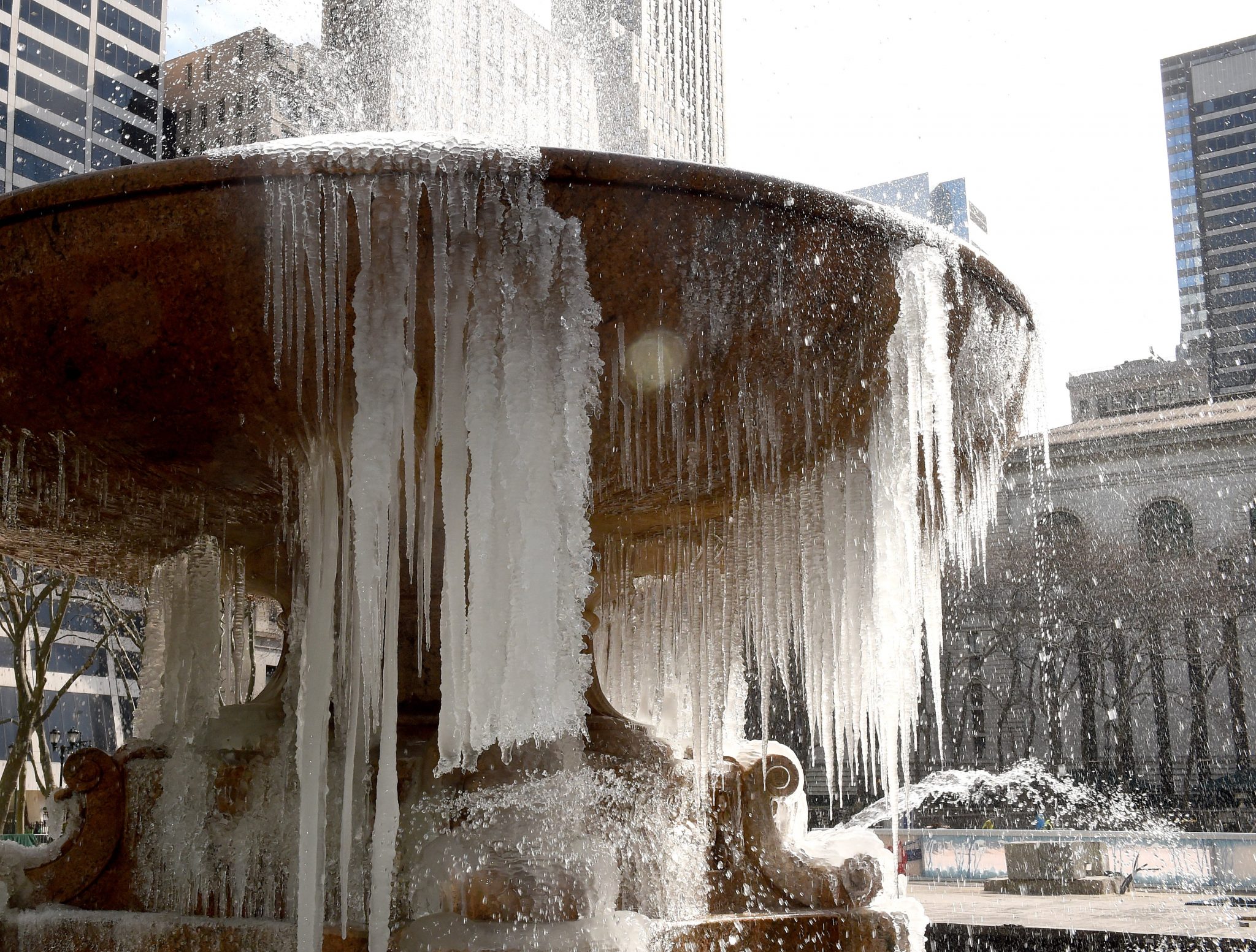 The  Josephine Shaw Lowell Memorial Fountain in Bryant Park is covered in ice on March 13, 2017 as the weather continues to be below freezing.  The northeastern United States braced Monday for what meteorologists predict could be the worst winter storm of the season, with blizzards feared to dump knee-high snow on New York. / AFP PHOTO / TIMOTHY A. CLARY