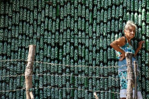 Eighty-six-year-old Maria Ponce, stands outside her house -- made out of plastic bottles -- in the village of El Borbollon, El Transito, west of San Salvador, on March 14, 2017. Maria built her house out of plastic bottles 12 years ago because she could not afford to build a conventional home. / AFP PHOTO / Marvin RECINOS